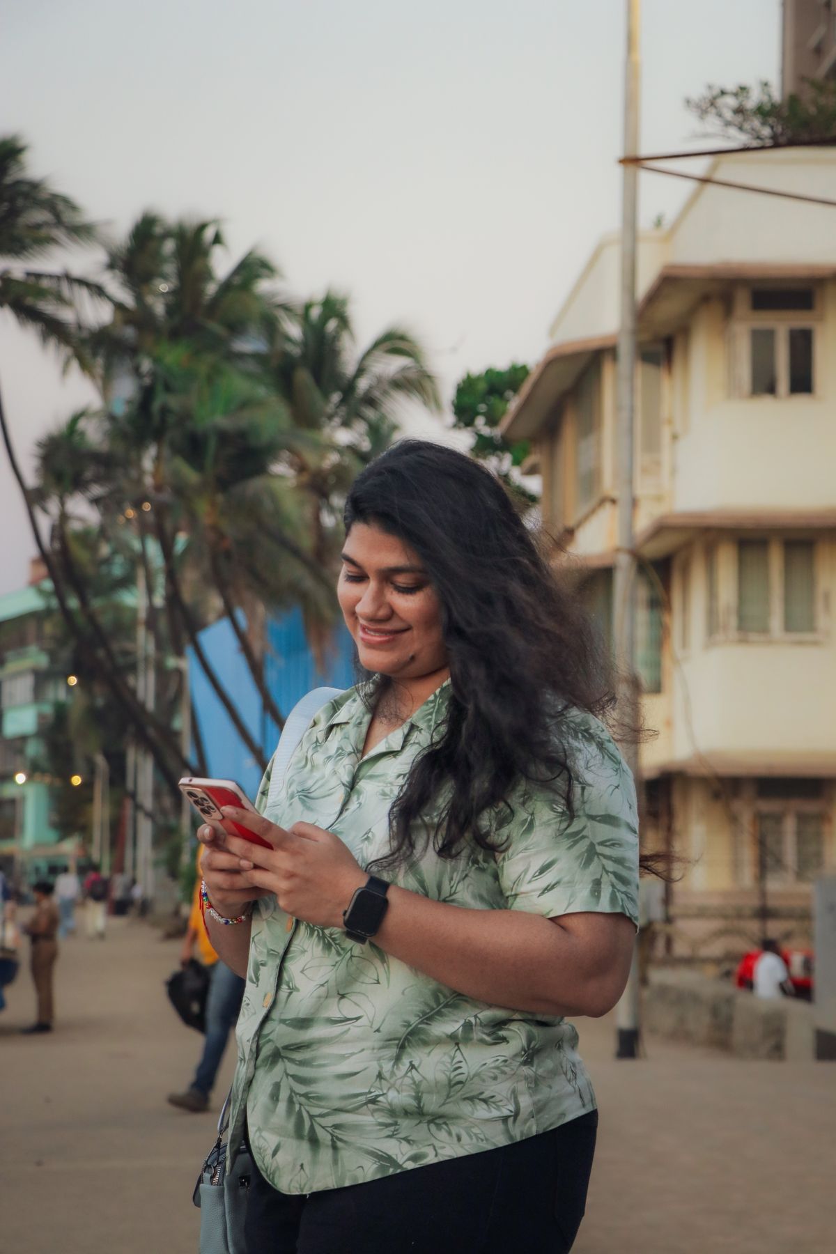 A woman smiling while checking a wellness app on her phone outdoors