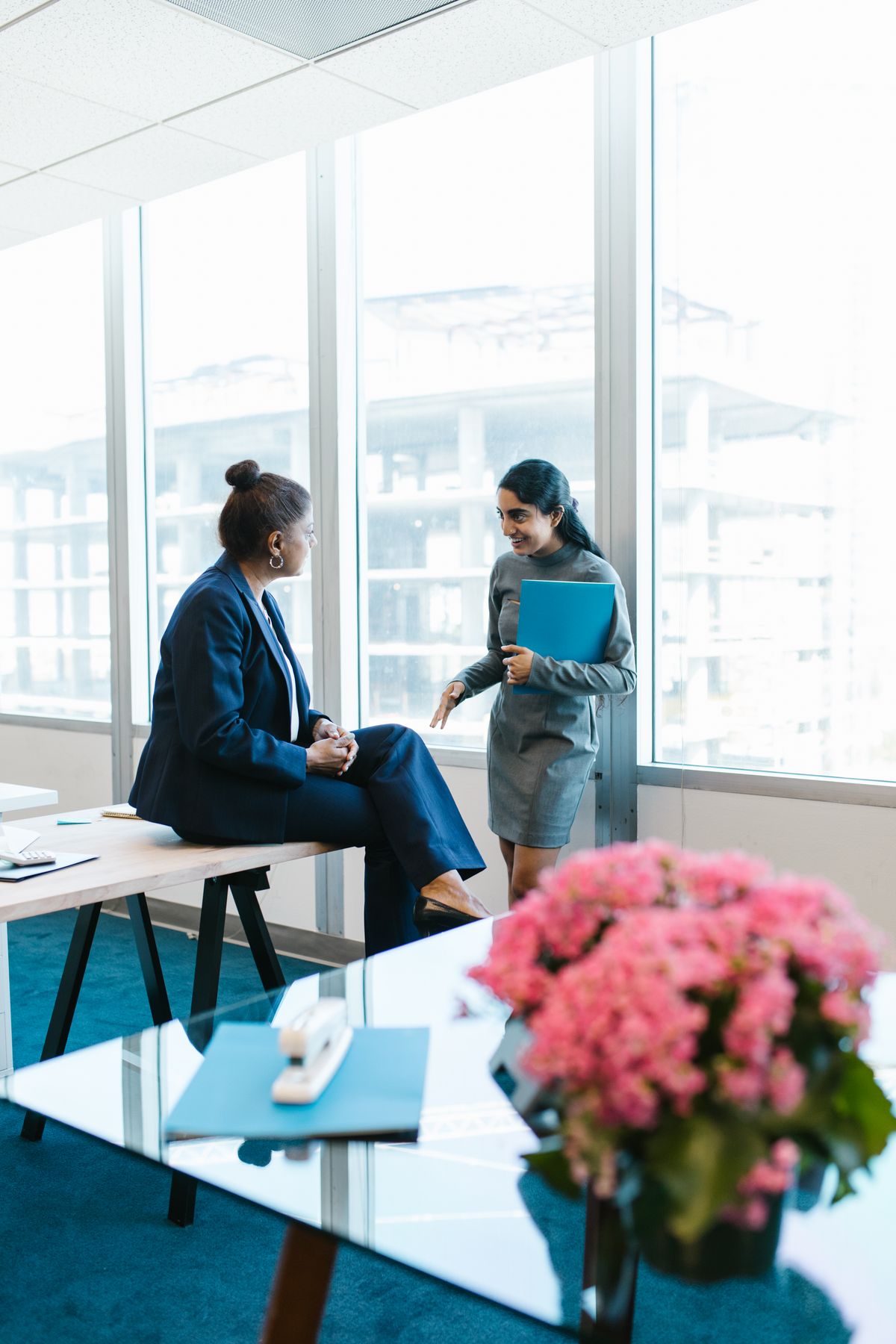 A therapist in conversation with a client on a couch, taking notes during a session